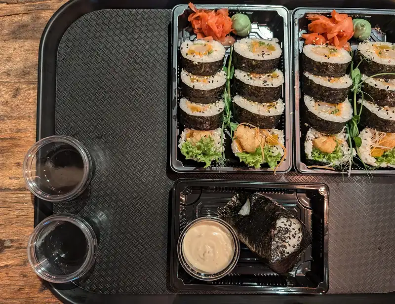 Dwa pudełka sushi na tacy z sosem sojowym