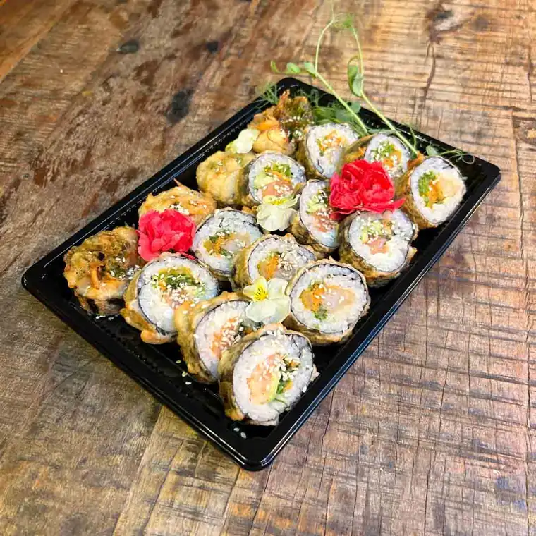 Uramaki w sezamie z kwiatem w czarnym pudełku